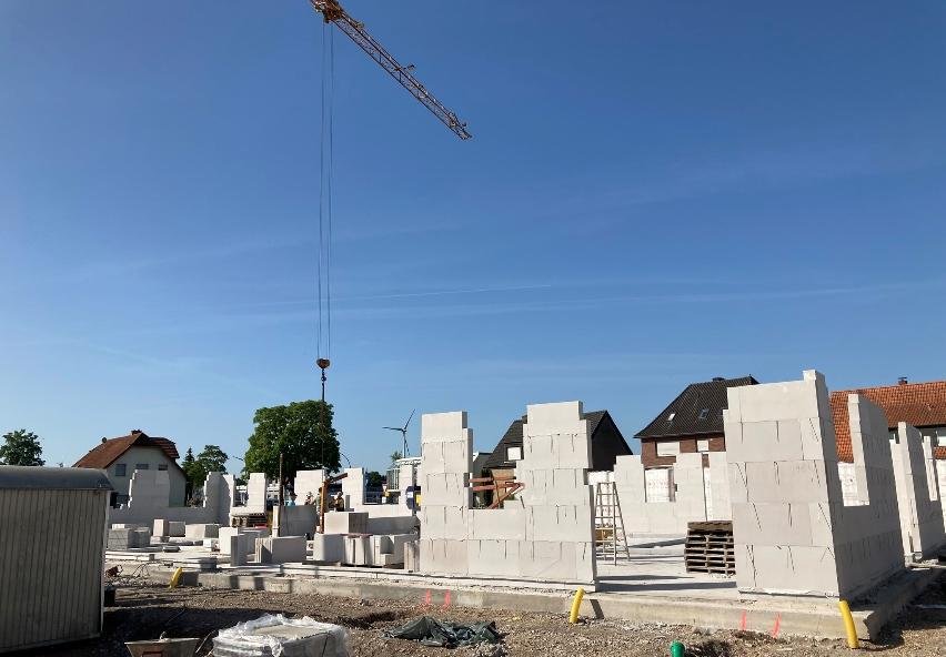 Blick über die Baustelle mit aufgehenden Wänden und Baukran