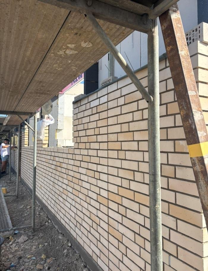 Helles Verblendmauerwerk an der Fassade hinter dem Gerüst