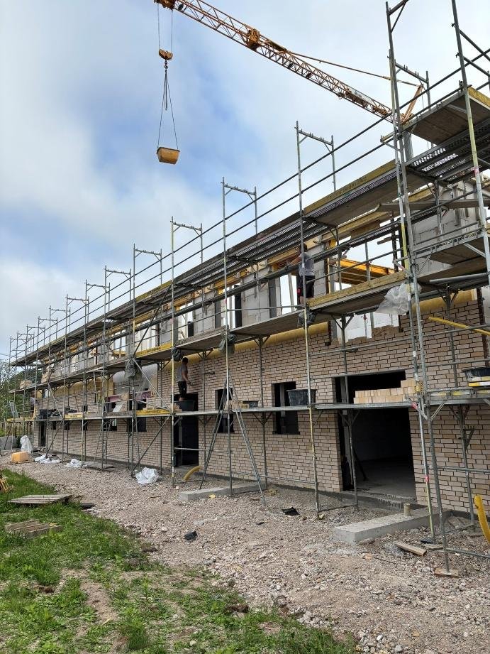 Eingerüstete Fassade mit fortschreitendem Verblendmauerwerk