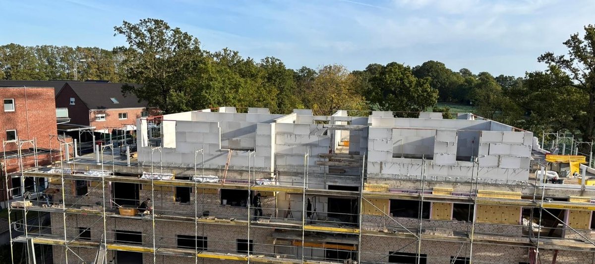 Eingerüsteter Rohbau mit Klinkerfassade und Mauerwerk im Staffelgeschoss